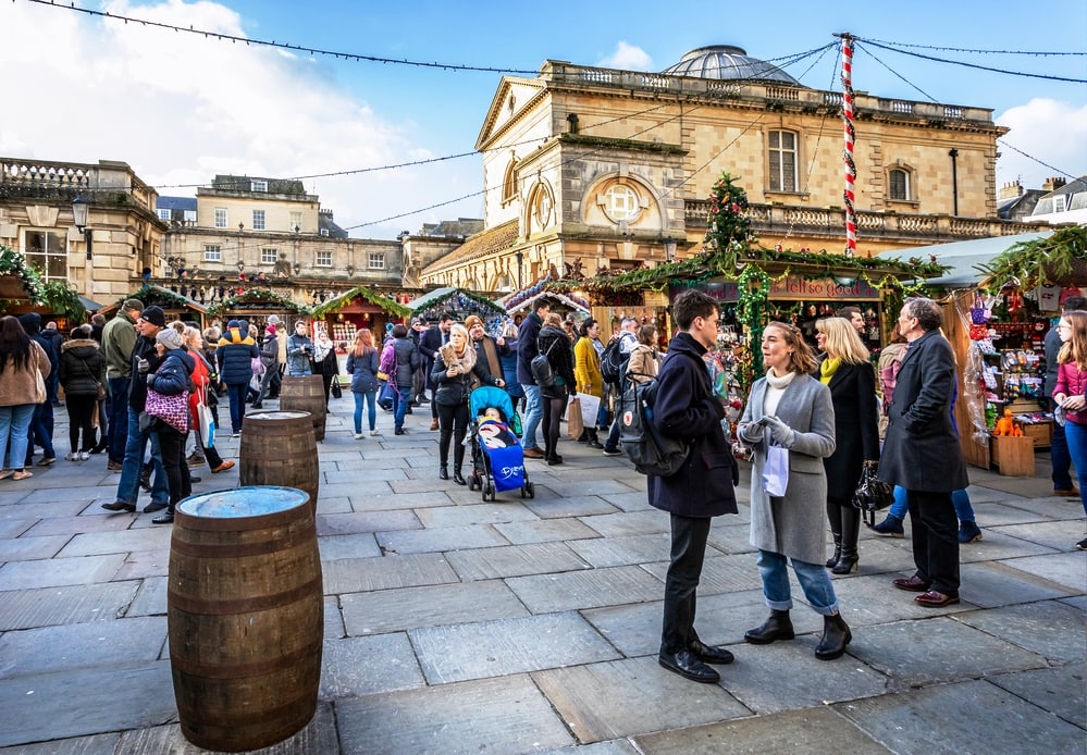 Market stalls and Roman Baths near the  Bath Abbey at Bath Christmas Market, Bath, Somerset, UK on 13 December 2019
