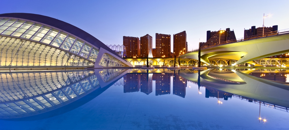 Valencia's City of Arts and Science Museum (Ciudad de las Artes y de las Ciencias) Two very modern swooping structures of glass and metal flank a blue lake with large towers in the background