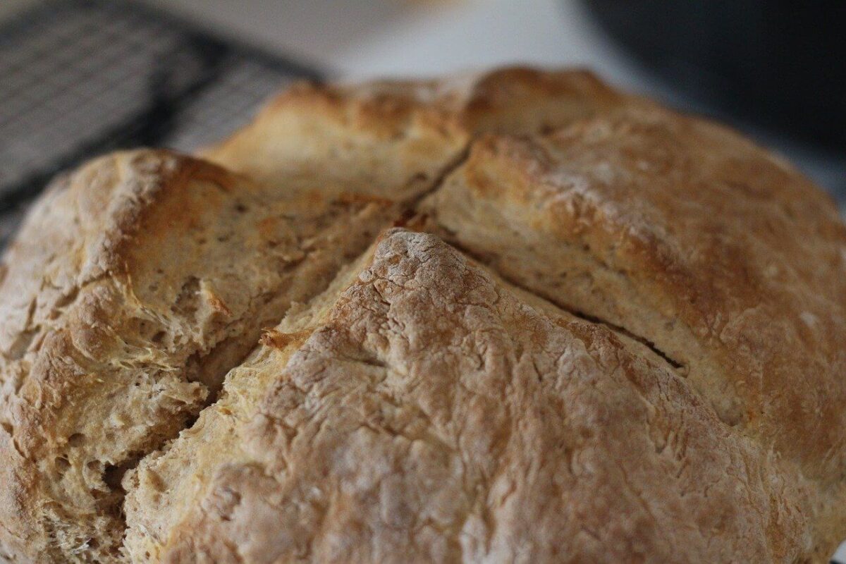 A round Irish soda bread with a cross cut in the top of the loaf