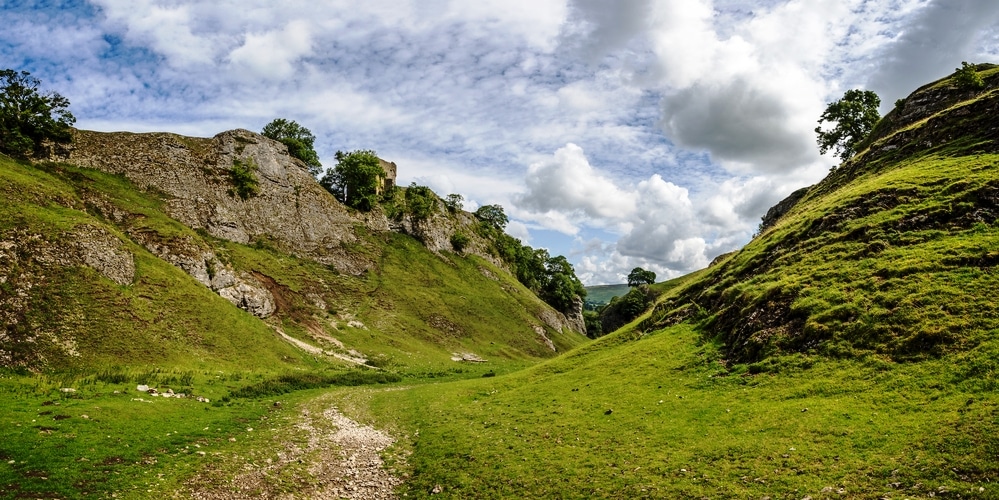 Peveril Castle seen from the Cavedale limestone valley in the High Peak District, Castleton, Derbyshire, UK on 25 July 2023
