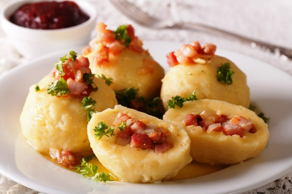 Swedish Potato dumplings with bacon, onion and ham close-up and Lingonberry sauce. 