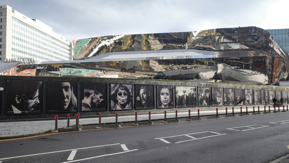 'Made In Birmingham' mural outside New Street Station featuring characters from the Peaky Blinders television series. A vibrant building adorned with an abundance of colorful artwork, displaying stunning pictures on its sides.