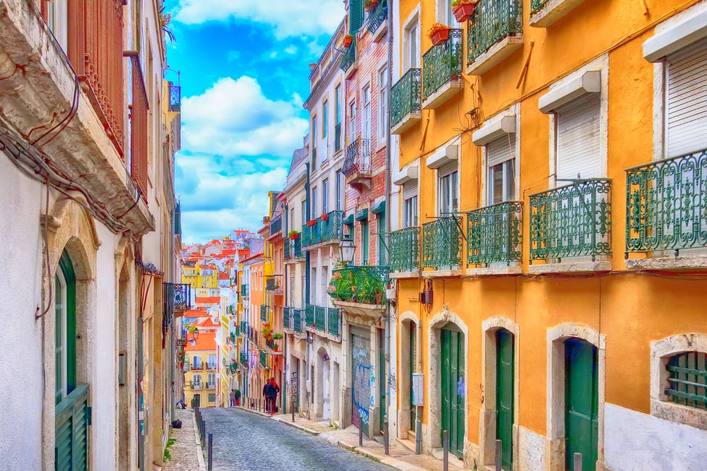 A narrow street in lisbon, portugal. The Alfama District of Lisbon. One of the best things to do in Lisbon is to do a walking tour through these colourful houses.