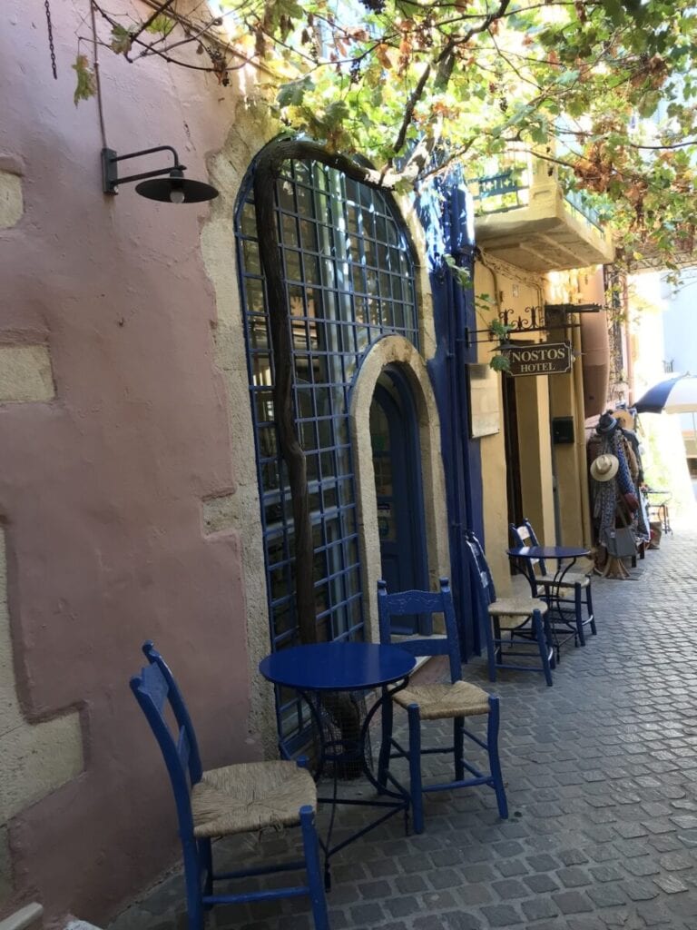 Blue chairs on a cobblestone street. Things to do in Chania Crete
