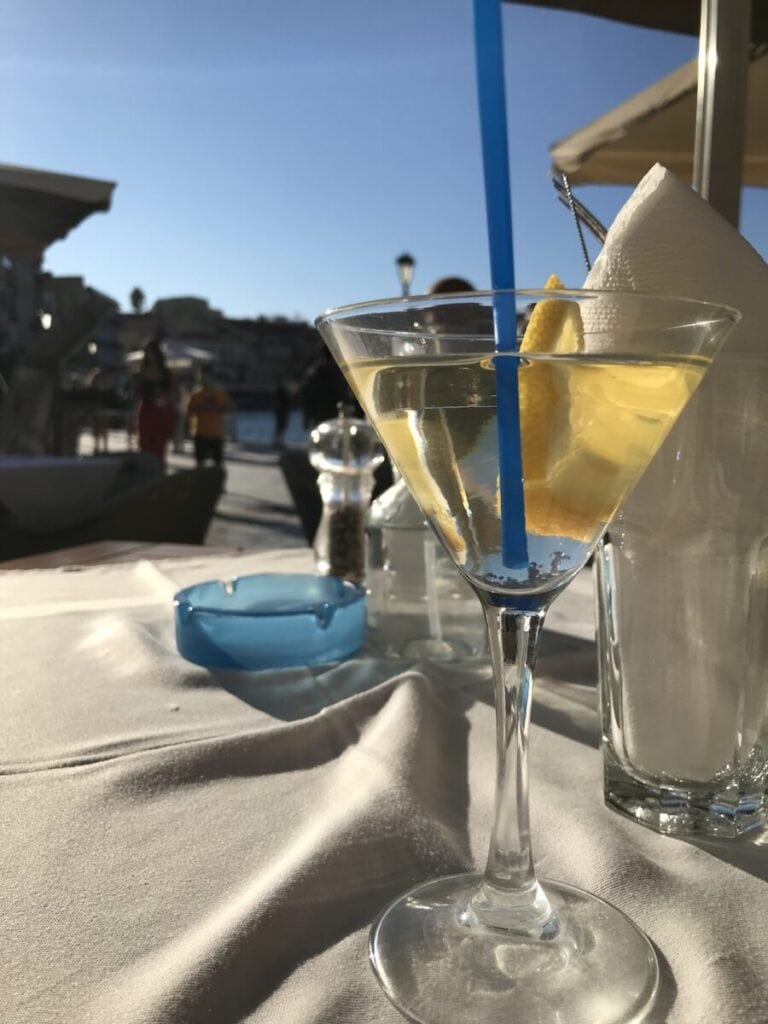 A martini in a glass on a table in a restaurant.