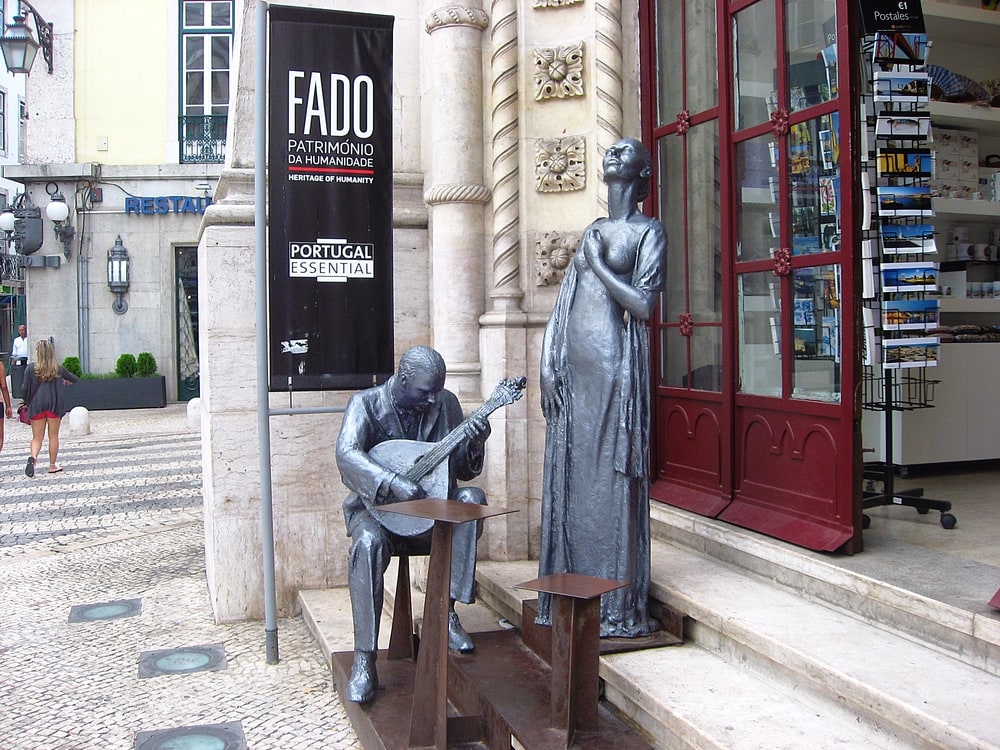 Celebrating Fado music in Lisbon with A statue of a man and a woman sitting on a bench.