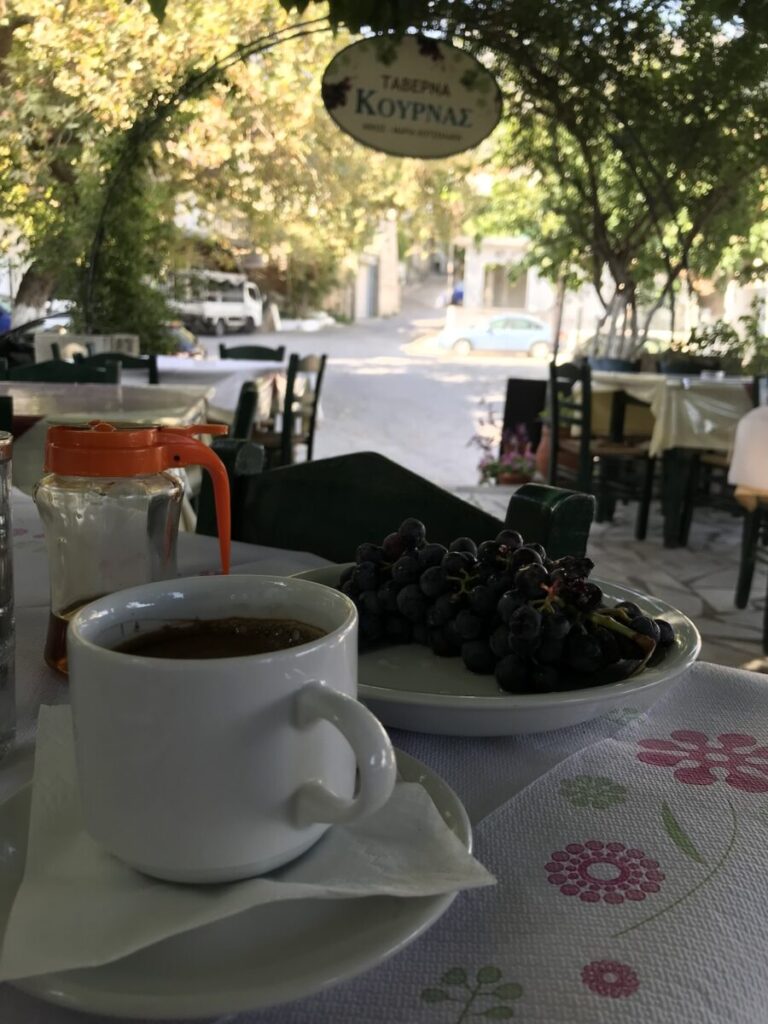 One of the many things to do in Chania is to enjoy a cup of coffee and indulge in some delicious grapes, all while sitting at a picturesque table.