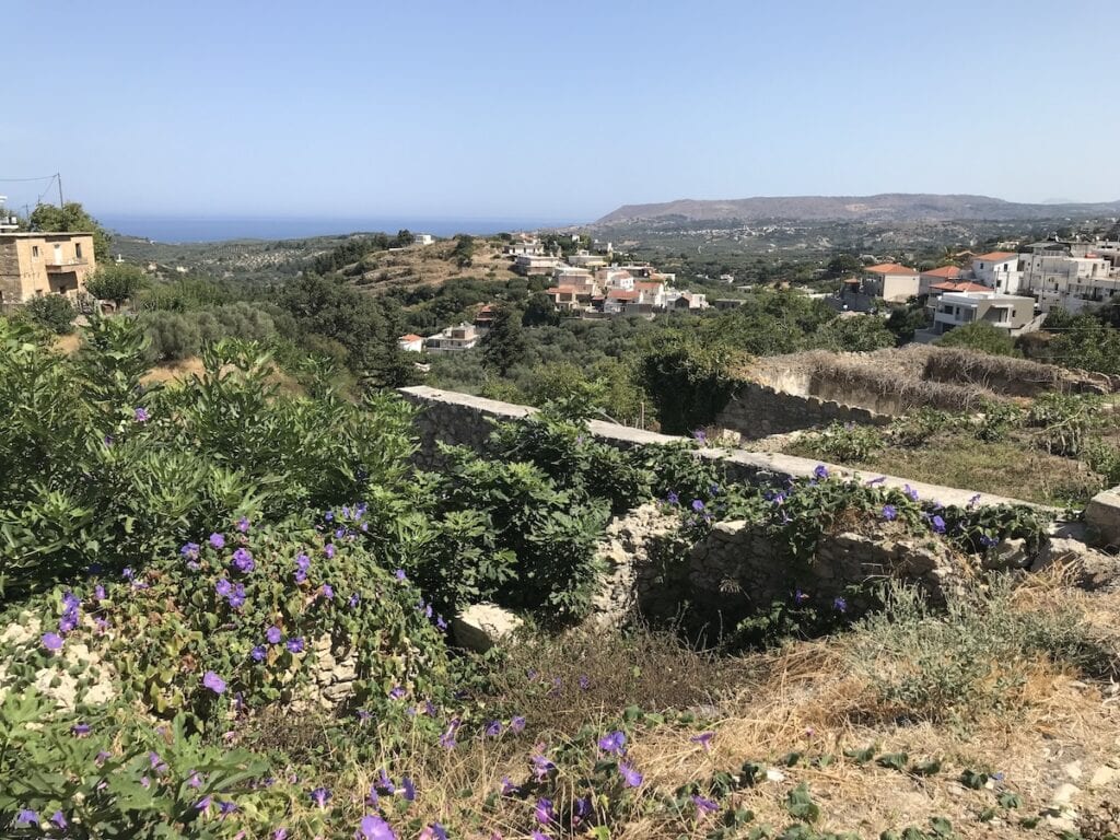 One of the stunning attractions in Chania is a picturesque hillside adorned with vibrant purple flowers and offering breathtaking views of the sparkling sea.
