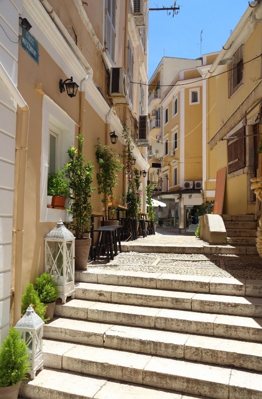 One of the best things to do in Corfu is explore the charming narrow street lined with stairs and potted plants.
