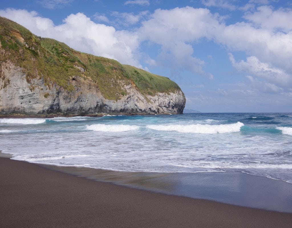 One of the best beaches in Portugal, this black sand beach features a stunning cliff in the background.