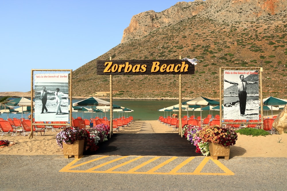 Stavros, Crete island / Greece - from the famous beach of Zorba the Greek in Stavros on creteA sign with flowers and umbrellas on a beach.