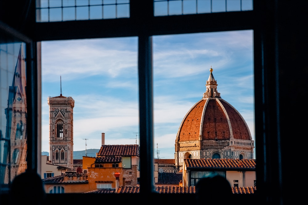 A view of Florence, one of the best places to visit in Italy, from an open window.