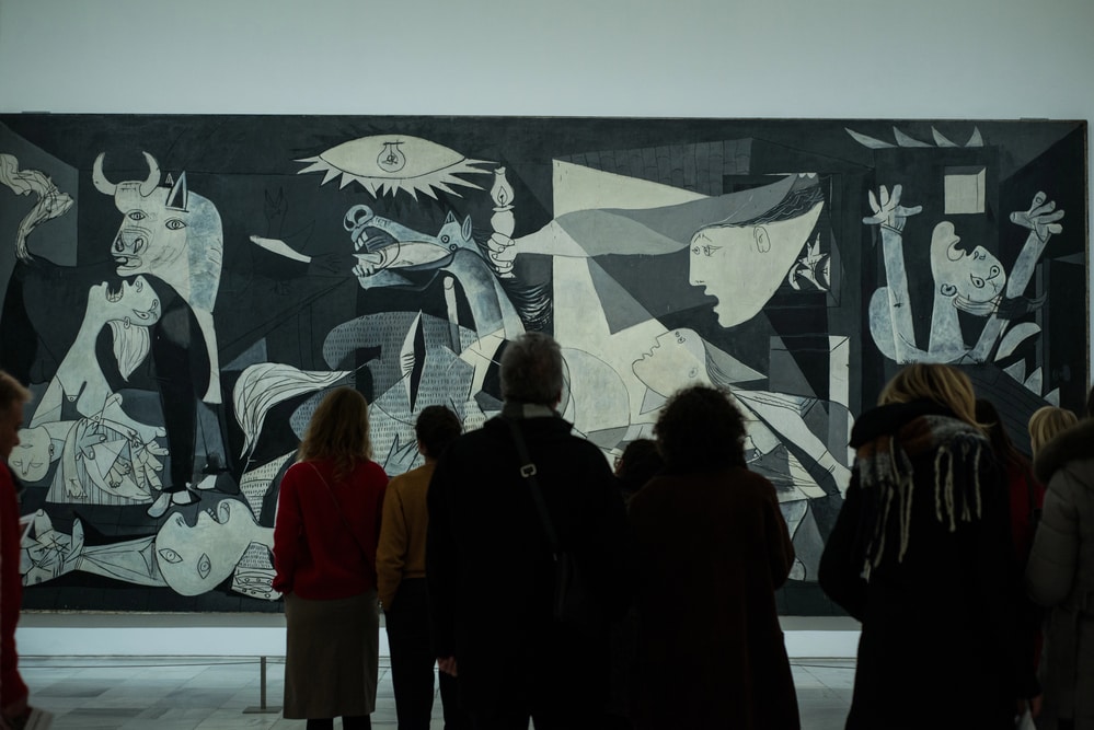 Visitors observing Picasso's "Guernica" at a museum exhibit one day in Madrid.