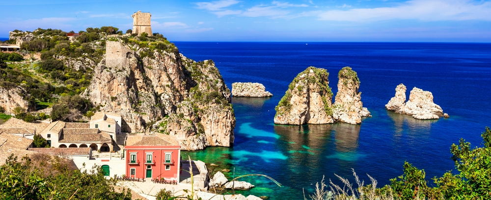 A rocky cliff overlooking the ocean, one of the best places to visit in Italy.