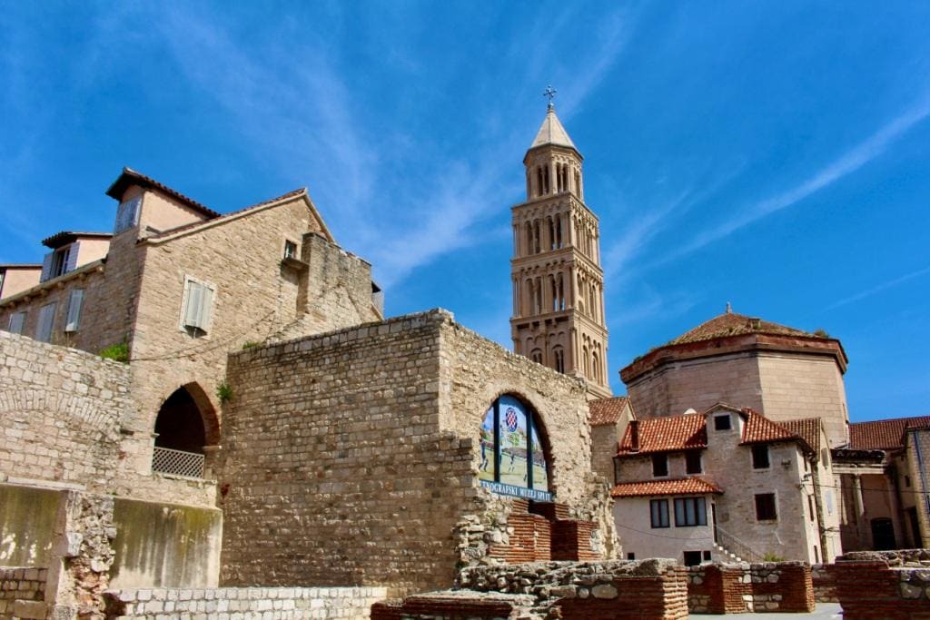 Historic stone architecture and a bell tower under a clear blue sky are standout things to do in Split, Croatia.