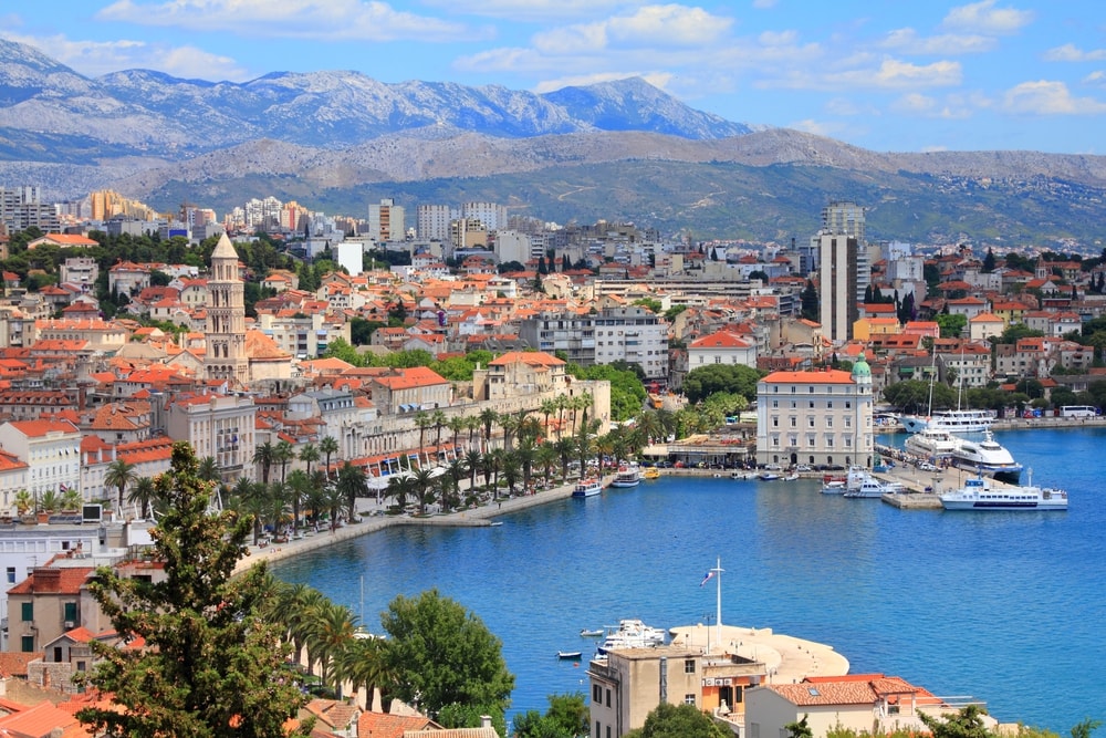 Split, Croatia (region of Dalmatia). UNESCO World Heritage Site. Mosor mountains in background.. Coastal city with historical architecture near a marina under a mountainous backdrop offers numerous things to do in Split, Croatia.