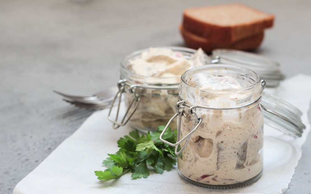 Two glass jars with traditional food of herring in sour cream a favourite in Norway in them.