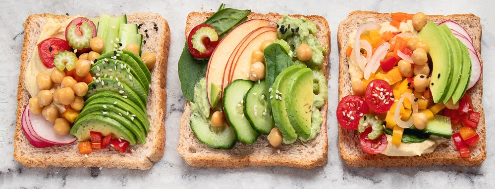 Three slices of bread with different vegetables popular in Norway on them.