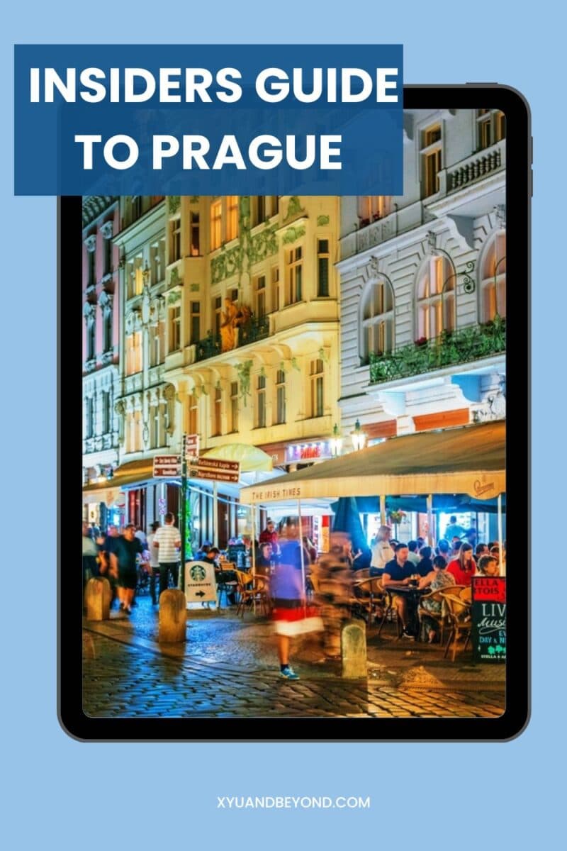 E-book cover titled "Insiders Guide to Visit Prague" displayed on a tablet, featuring an image of a lively street scene at night in Prague with people dining outdoors.