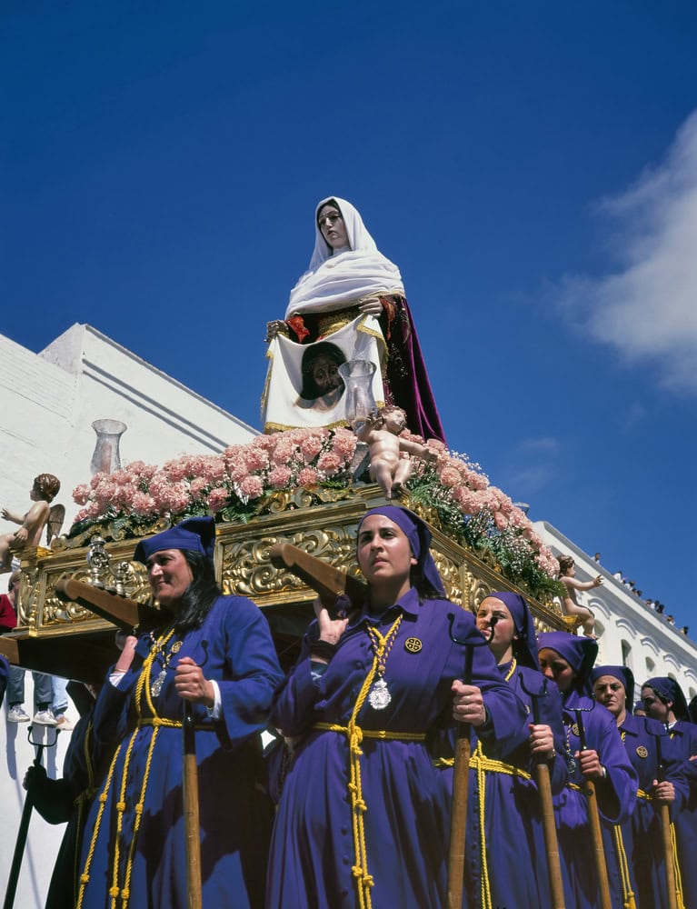 ARCOS DE LA FRONTERA,SPAIN-APRIL,21 2000: A group of female bearers carrying a religious float (known as a Tronos) in the processions held to participate in the procession.