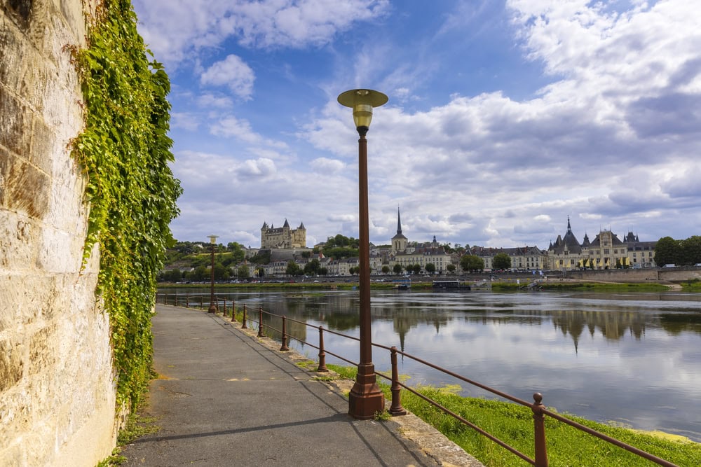 Town of Saumur, France, located at the Loire river under a beautiful cloudscape during daytime.