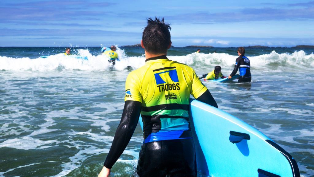 people heading into the surf to ride their surf boards