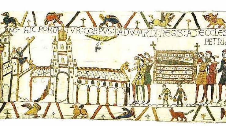 A medieval-style embroidery depicts a building, a hand descending from above, and figures carrying a decorated rectangular