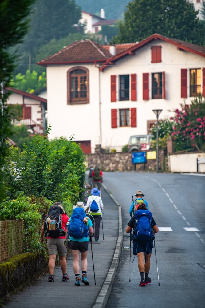 ilgrims with backpack walking the Camino de Santiago, Saint Jean Pied de Port in Pays Basque, France, Europe