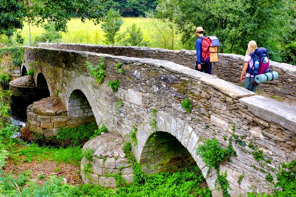 Pilgrims on the Ponte da Áspera on the Camino de Santiago near Sarria, Galicia, Spain