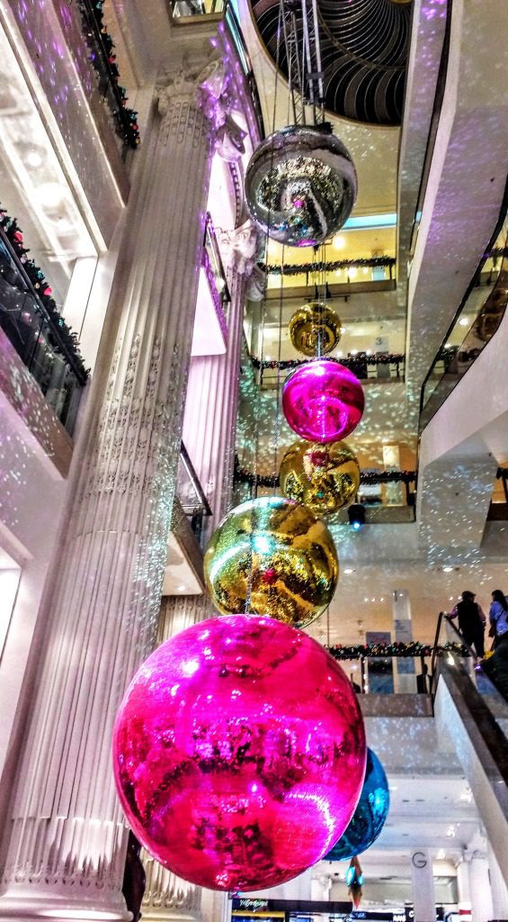 Selfridges giant Christmas baubles in pink and gold hang above the store escalators