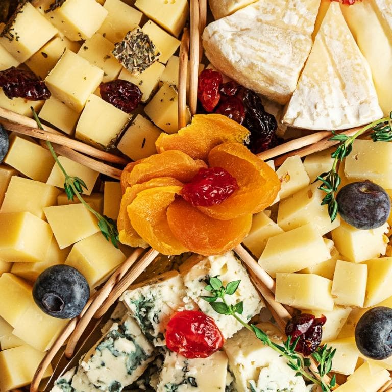 Various sorts of cheese on a plate, top view