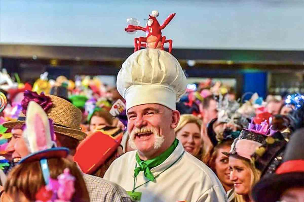 A man dressed in chefs clothes with a lobster on his head at the Gourmet Food Festival 