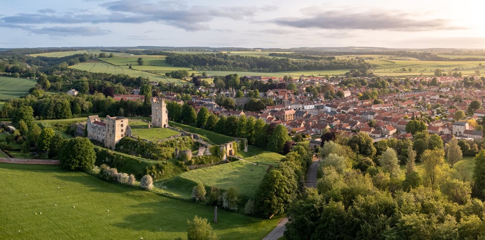 HELMSLEY CASTLE, NORTH YORKSHIRE, UK Aerial panorama of Helmsley Castle and town with surrounding North Yorkshire Moors countryside at surise