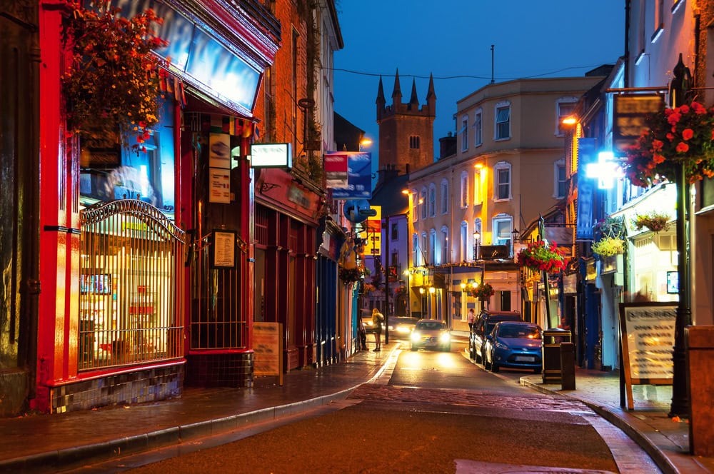 Nightlife at the medieval old part of the popular touristic city Ennis, Ireland. It hosts many restaurants and bars, blurry people at the street