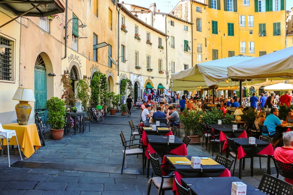 Lucca, Italy - Circa September 2018. Tourists visit famous square Piazza dell'Anfiteatro in Lucca.