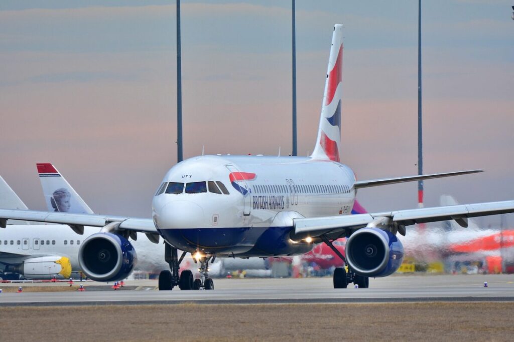 A British Airways aircraft taxiing on the runway at an airport, with the tail fin prominently displaying the Union Jack. 