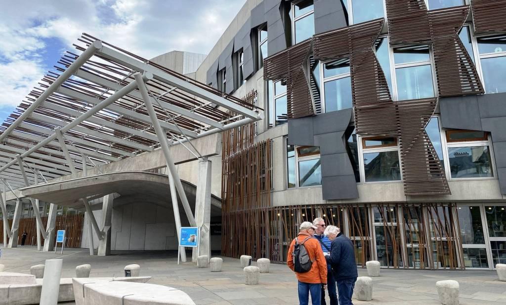The modern Scottish Parliament building in Edinburgh. The portico is decorative iron rods in front of a very modern building