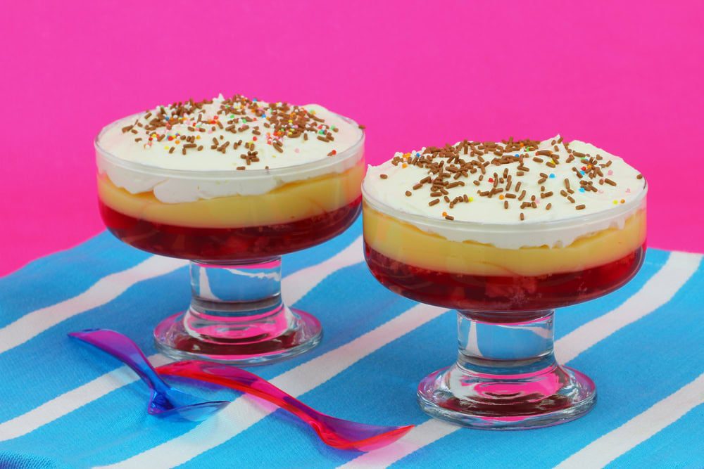 Traditional strawberry trifle, layers of jelly, custard and cream with multi-coloured sprinkles on top