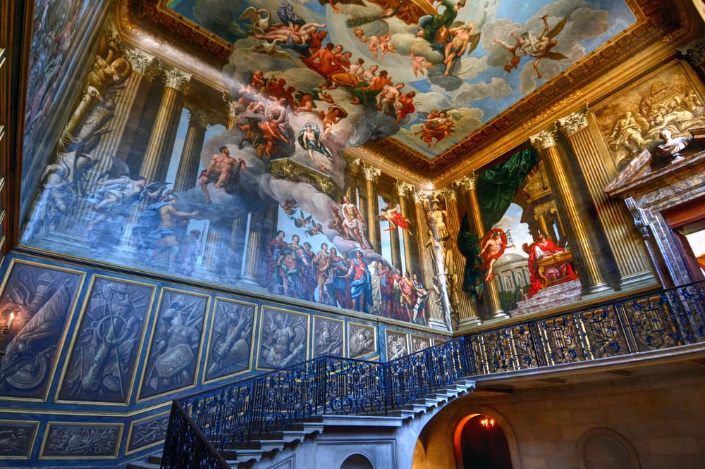 The great Hampton court Staircase with intricate iron railings and stunning images pained on the walls.