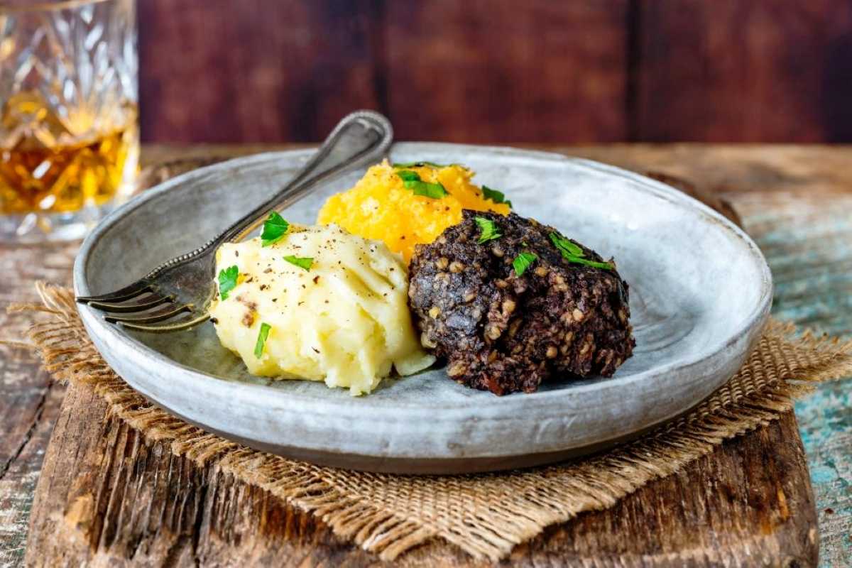 Neeps (turnip) tatties (potatoes) and Haggis on a white plate