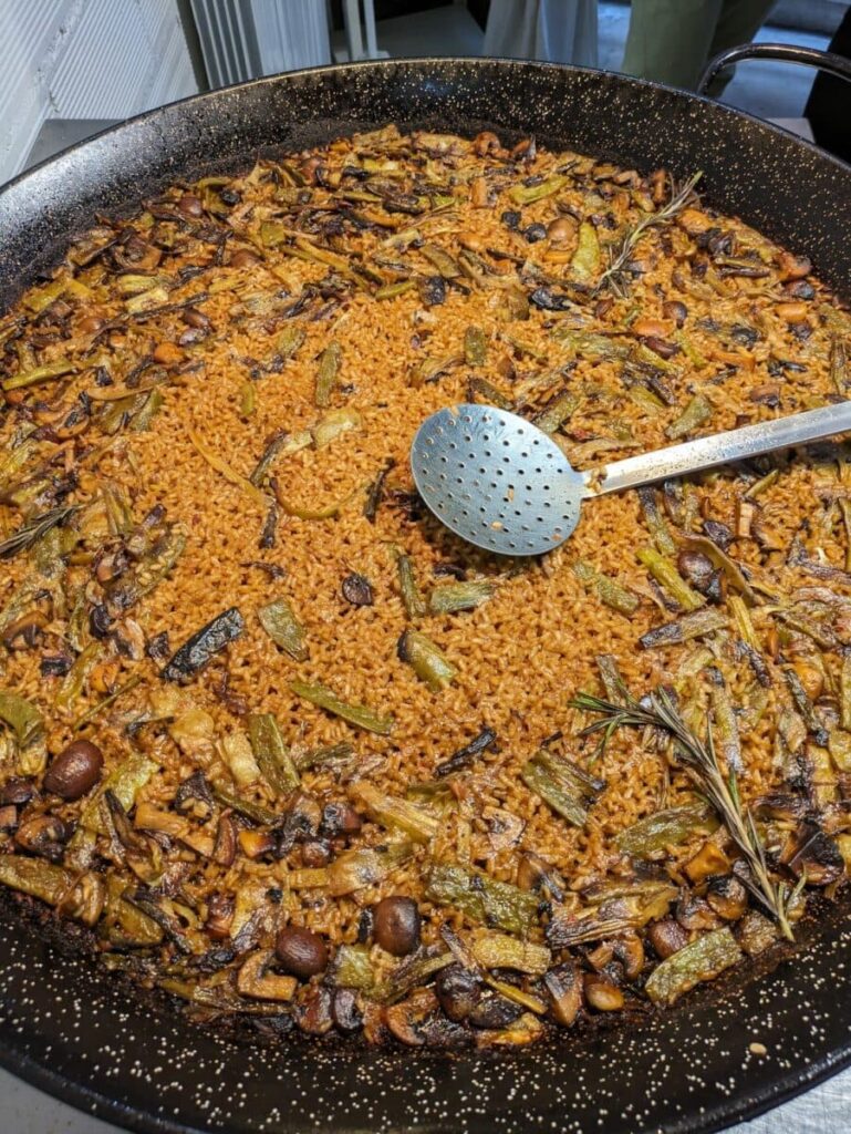 A large dish of vegetarian paella with rise, chestnuts, rosemarhy and aparagus