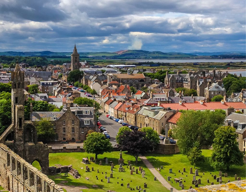 a historic and iconic golf course located in St Andrews, Scotland, featuring the world-renowned Old Course with its distinctive double greens, deep bunkers, undulating fairways, and the famous Swilcan Bridge, all set against a rugged coastal landscape with sweeping views of the North Sea.