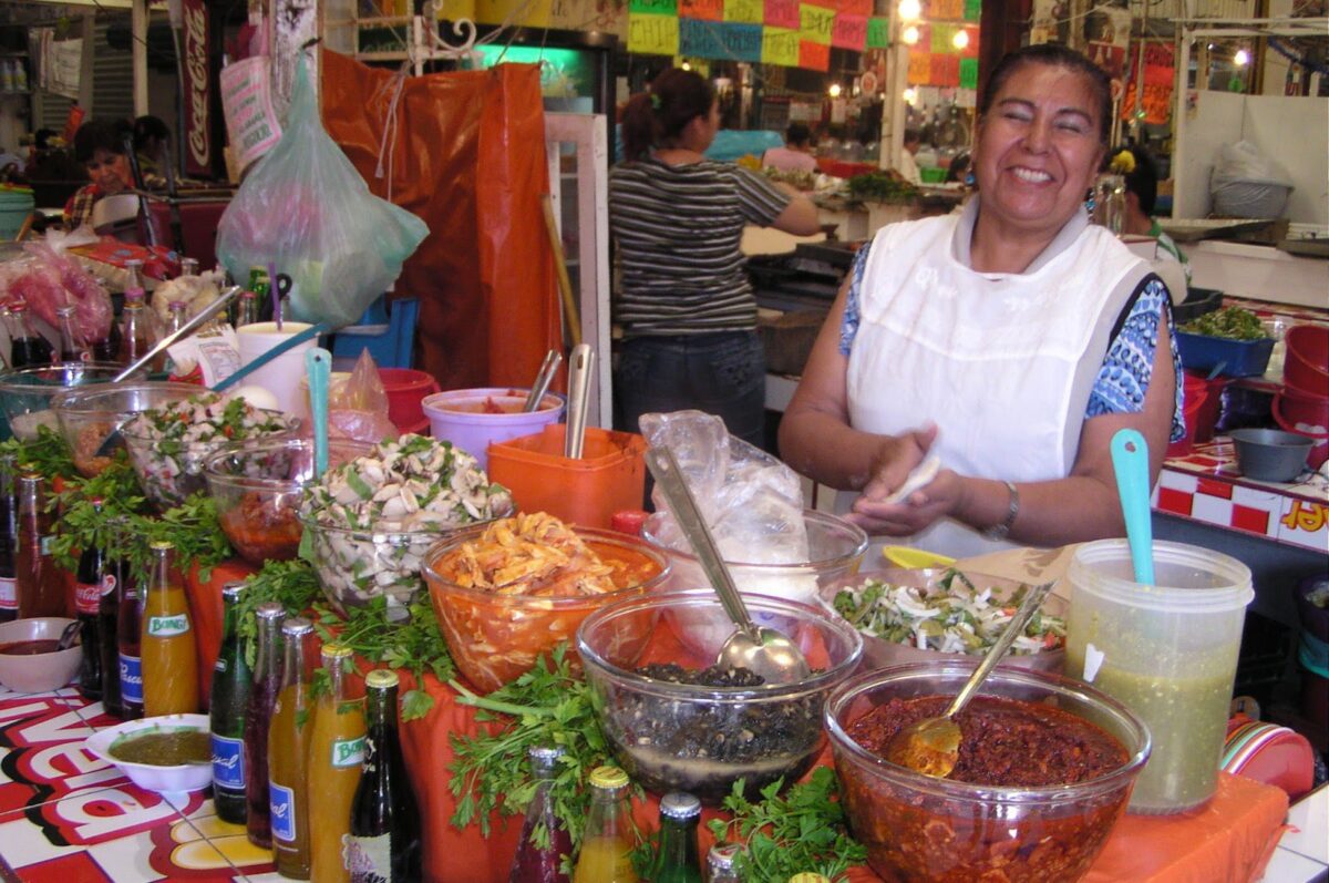 A Mexican lady in the market making tortillas
