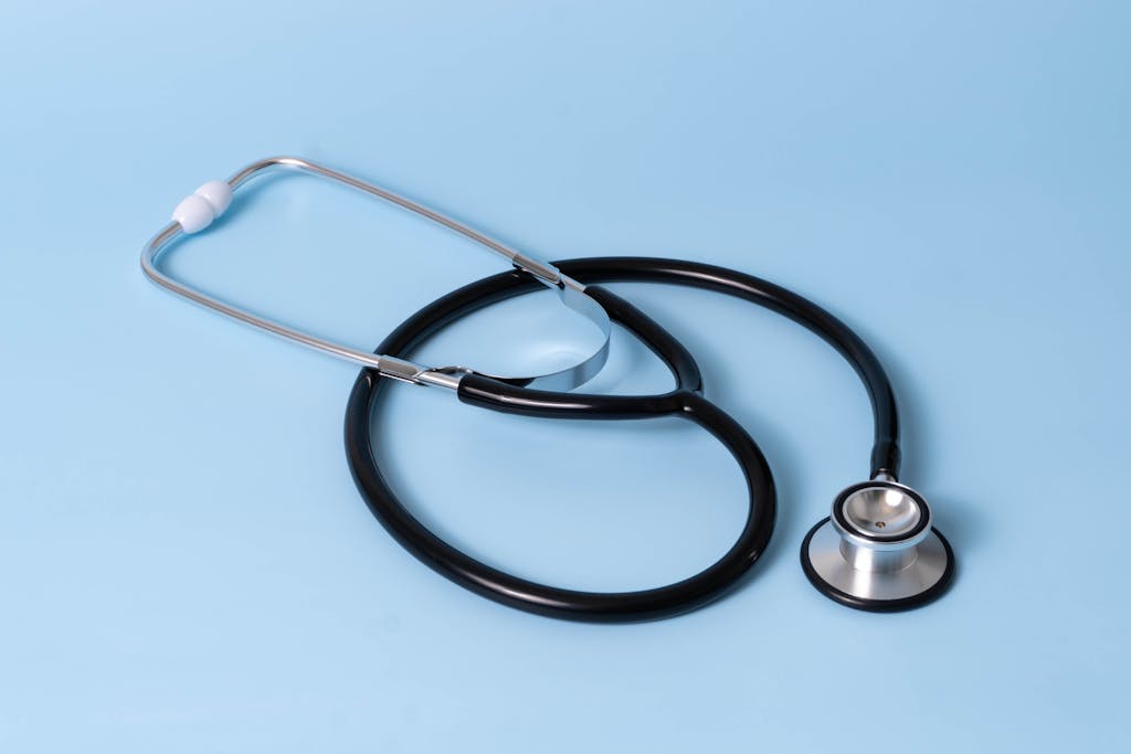 Close-up of a classic stethoscope on a blue background, symbolizing healthcare and medical profession.