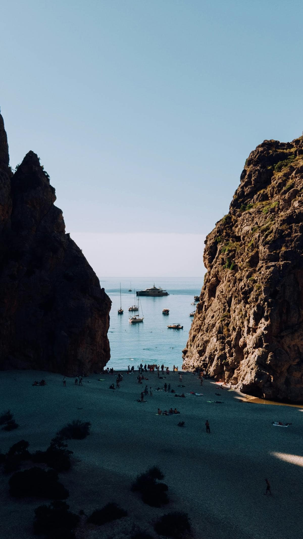 Majestic rock formations framing a serene beach and sea at La Calobra in Mallorca, Spain.