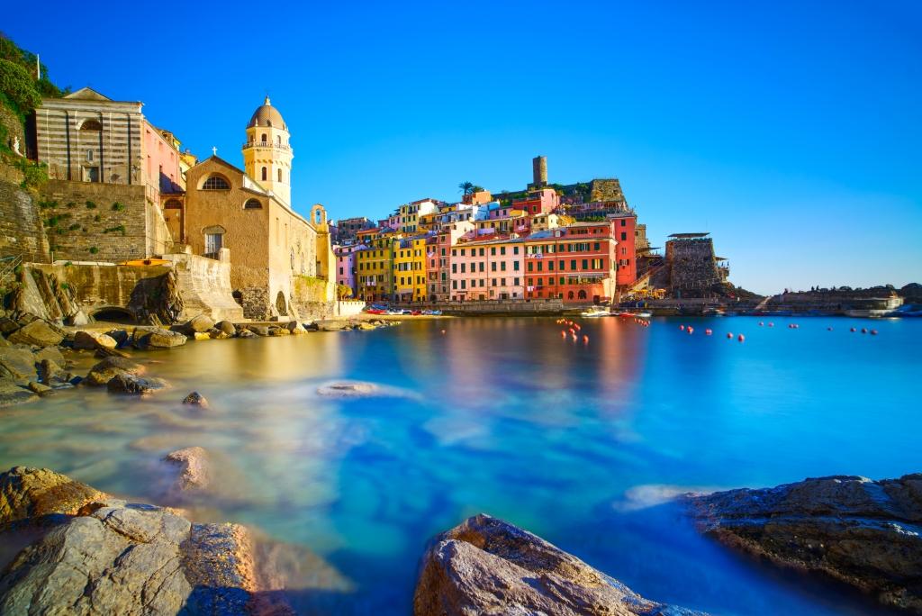Vernazza village, curch, rocks and sea harbor on sunset. Cinque Terre, Ligury, Italy