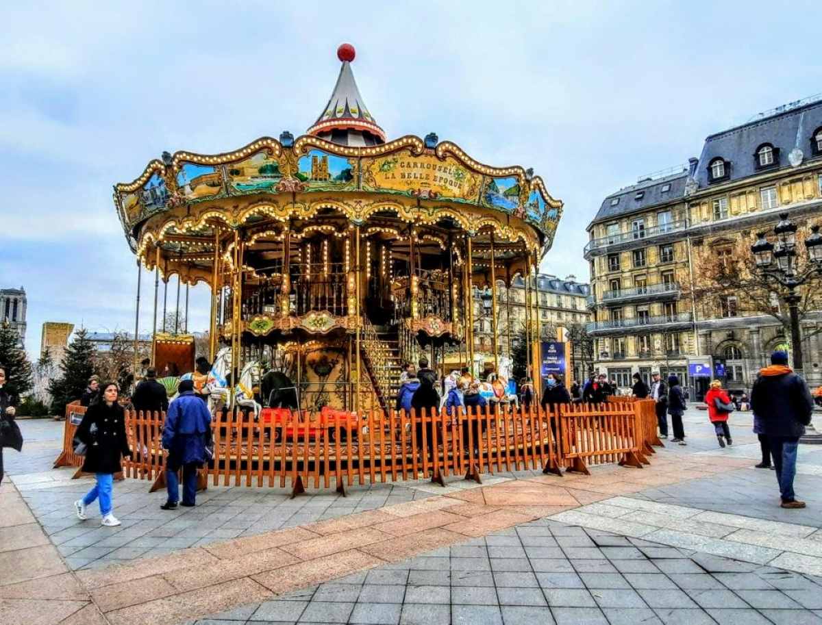 An antique carousel in golds and lights at the city hall in Paris
