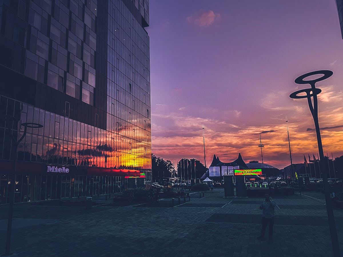 Colorful sunset reflecting on modern buildings in Bucharest urban scene.