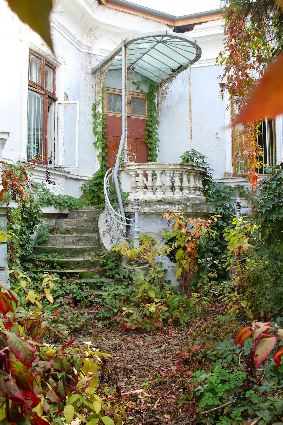 Explore the charm of an abandoned mansion with ivy and autumn foliage in Bucharest, Romania.