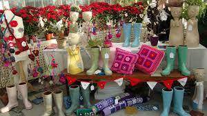 Display of colorful boots, pillows, and decorations on a table with poinsettias.